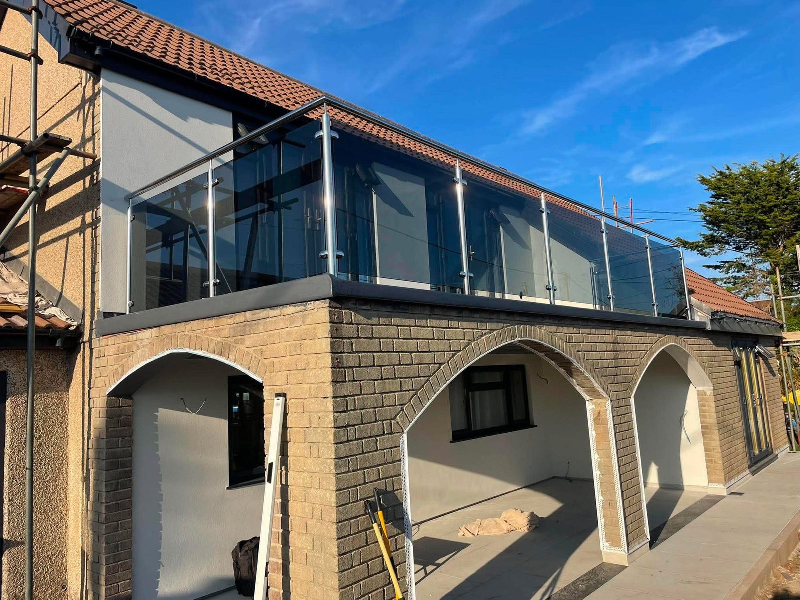 Stainless steel and glass balustrade wrapping the corner of a first-floor balcony